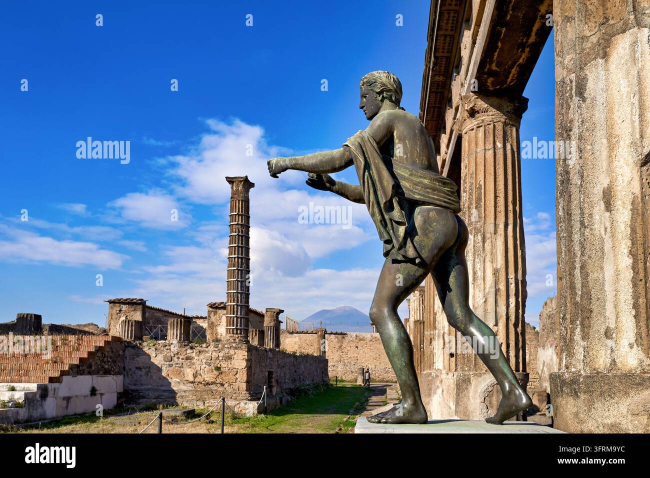 Statua di arciere in bronzo nel Tempio di Apollo, con colonne in rovina e il vulcano Vesuvio sullo sfondo, antica città romana vicino a Napoli, Campania Foto Stock