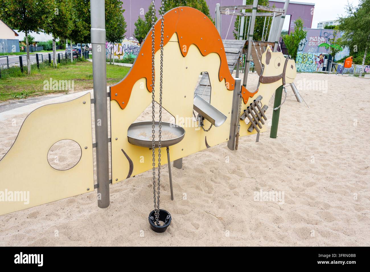 Bambini giocano su un campo da gioco in sabbia a forma di cammello in un parco cittadino. Gioco all'aperto, infanzia, immaginazione, apprendimento tattile, comunità, famiglia, ricreazione Foto Stock