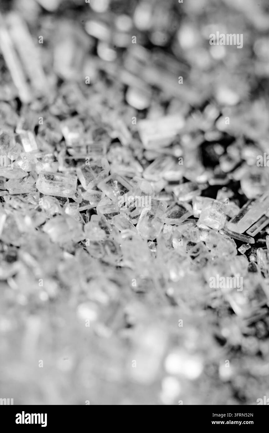 Estremo macro della trama dei cristalli di zucchero bianco, vista dettagliata della struttura cristallina minerale trasparente in bianco e nero, ingrediente dolce astratto Foto Stock