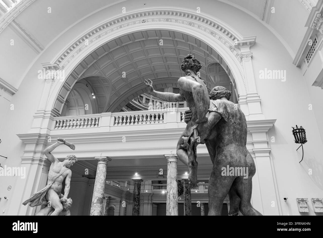 VISTA IN BIANCO E NERO DELLA SALA DELLE SCULTURE DEL MUSEO, REPORTAGE AL MUSEO V&A DI LONDRA, LONDRA, INGHILTERRA: Una drammatica fotografia in bianco e nero mostra grandi sculture classiche in piedi in una grande sala museale con soffitti alti e linee architettoniche marcate. INFO: Il Victoria and Albert Museum (V&A) di Londra è il principale museo mondiale di arte, design e performance. Con oltre 2,8 milioni di oggetti che coprono 5.000 anni, celebra la creatività umana attraverso la moda, l'architettura e i tessuti. Foto Stock
