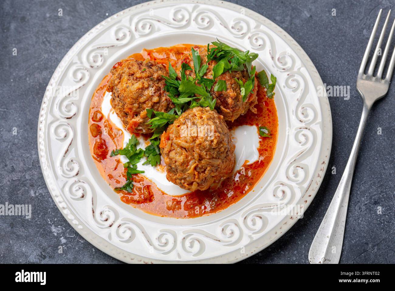 Polpette fatte in casa con carne, riso e verdure sono servite in un piatto su uno sfondo scuro. Vista dall'alto, primo piano Foto Stock