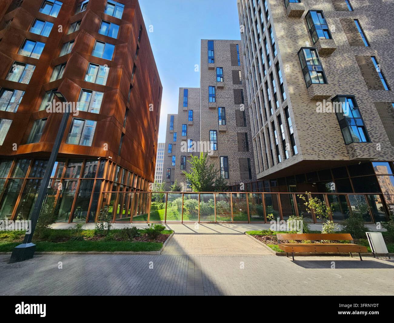 Edificio con un'area verde davanti. C'è una panchina davanti all'edificio Foto Stock