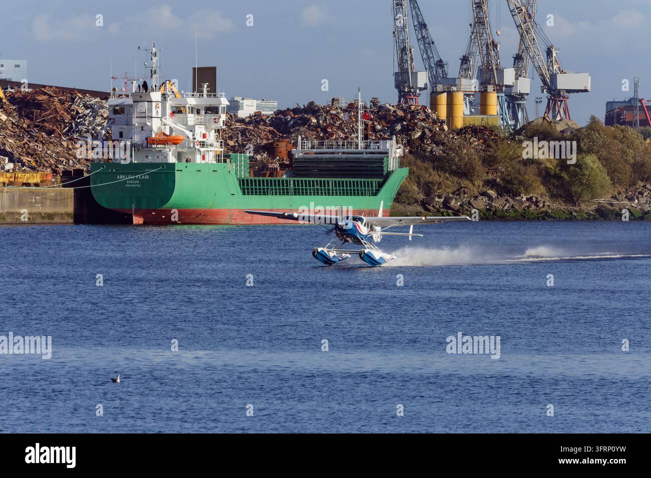 Una nave cargo sul fiume Clyde che carica o scarica rottami metallici accanto a una discarica di rottami su South Street nel 2007, Glasgow, Scozia, Regno Unito Foto Stock