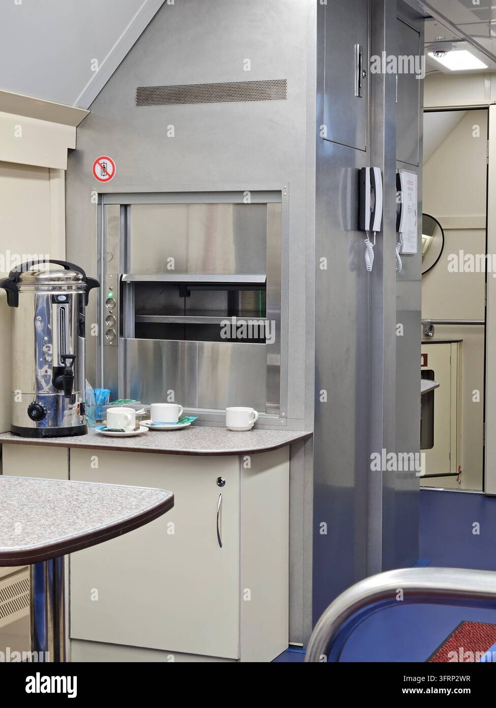 Cucina con una macchina del caffè e un microonde. Il microonde o l'elevatore per gli alimenti si trova sul lato sinistro della cucina nel ristorante sul treno, vagone ristorante, connessione di trasporto ferroviario a terra Foto Stock