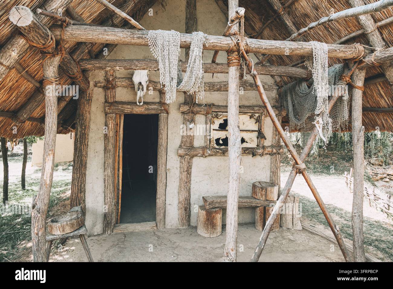 24 luglio 2026, Mali Dunav, Belgrado, Serbia: Reti da pesca appese e un cranio di animale decorano l'esterno di una capanna primitiva in fango e legno con tetto di paglia Foto Stock