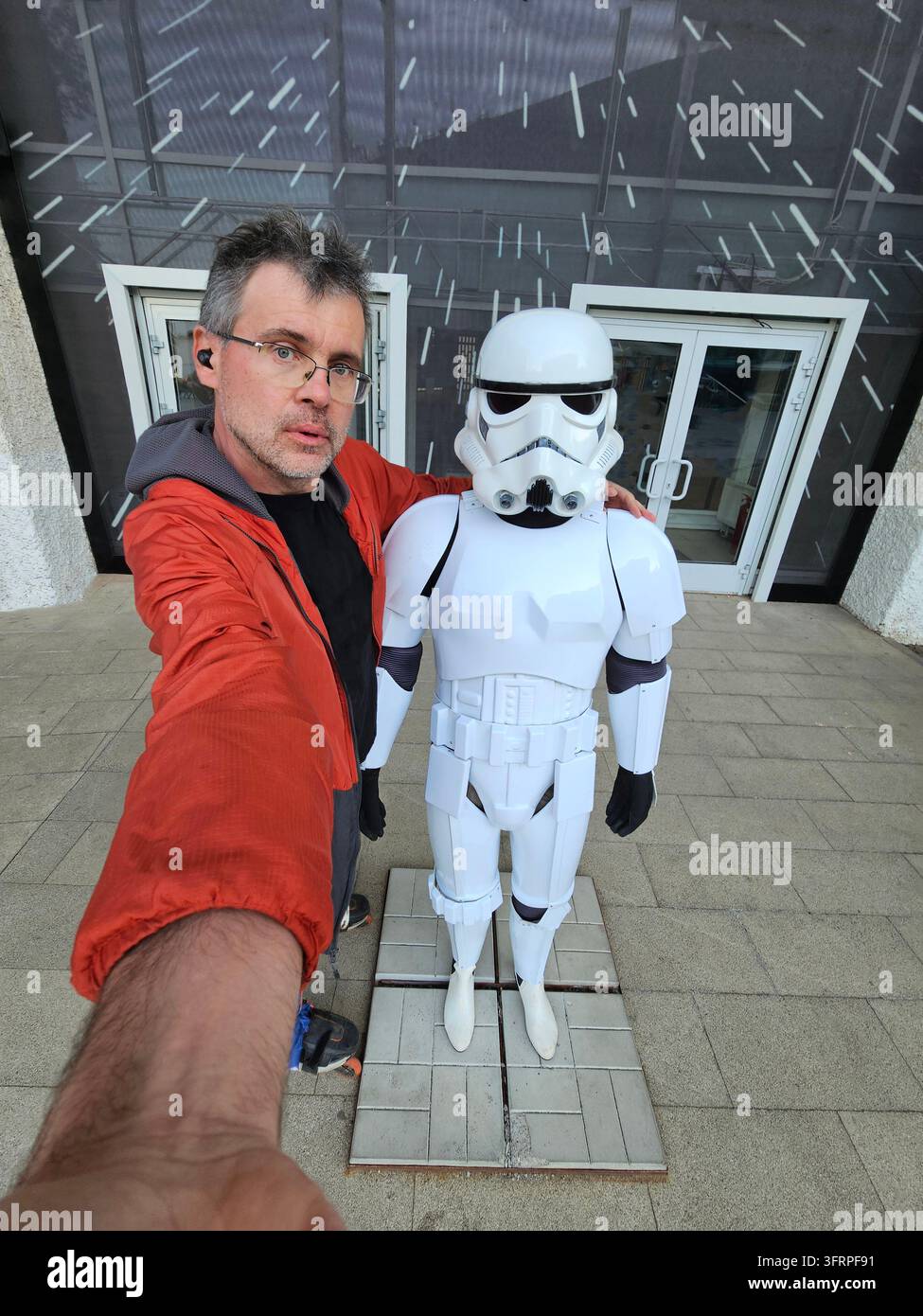Mosca – 19 maggio 2024: Un uomo (MR) sta scattando una foto di una figura di Star Wars. La figura è un soldato stormtrooper. L'uomo indossa una giacca rossa Foto Stock