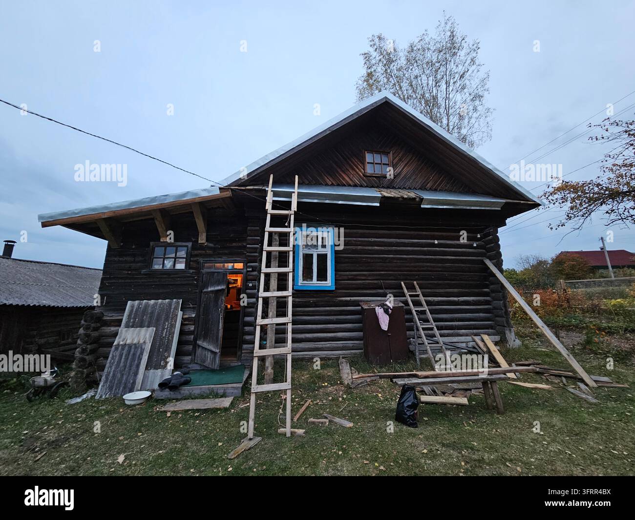 Casa con una scala appoggiata contro di essa. La casa è vecchia e ha molto legno Foto Stock