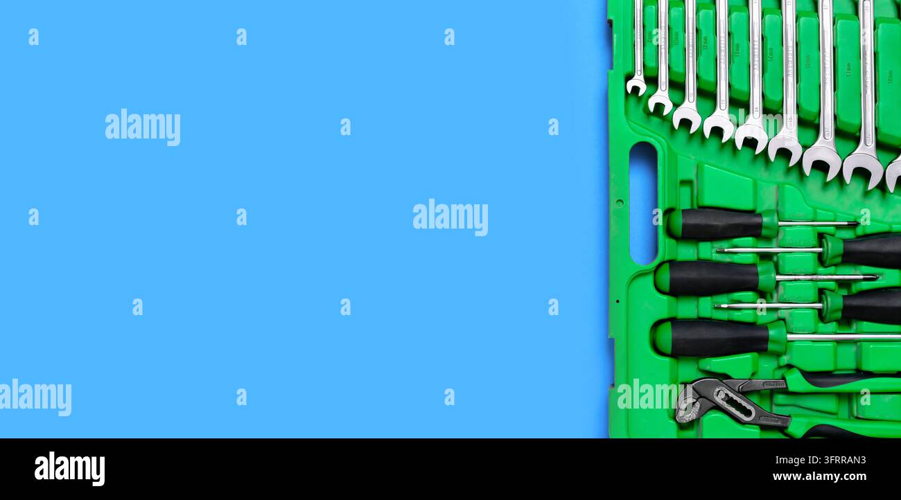 Set verde di utensili da costruzione: Chiavi, pinze regolabili, cacciavite e così via su sfondo rosso. Banner con spazio per il testo di un hardware Foto Stock