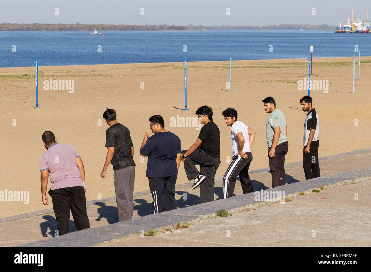 ARKHANGELSK, RUSSA - 25 SETTEMBRE 2026: Studenti indiani di medicina si trovano sulle scale del lungomare in pietra durante una lezione di educazione fisica all'università. Foto Stock