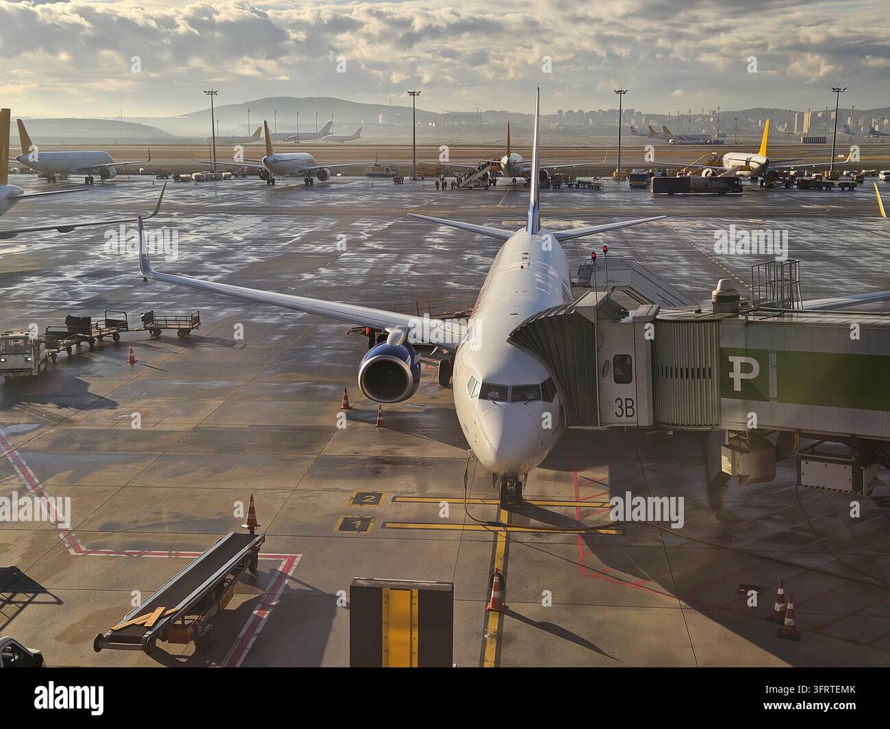 ISTANBUL - 30 SET 2025: Un grande aeroplano è parcheggiato sulla pista di un aeroporto. L'aereo è circondato da diversi altri aerei e ci sono persone che camminano nella zona. Concetto di freneticità Foto Stock
