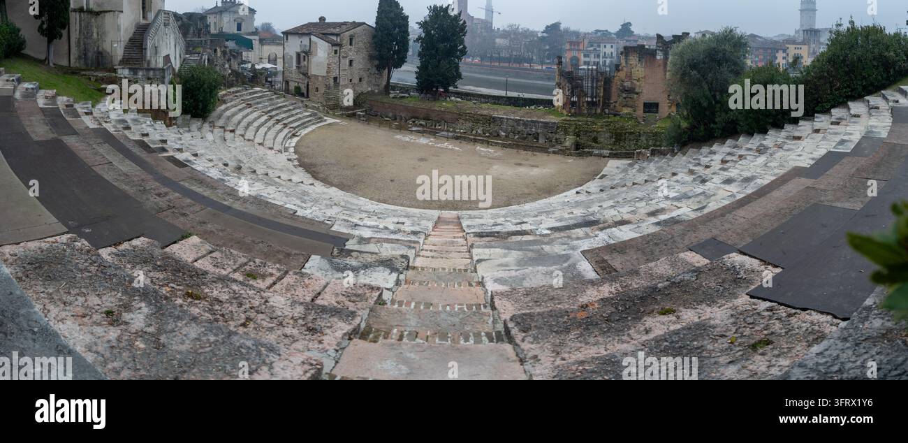 Vista panoramica dai sedili in pietra dell'antico teatro romano di Verona, che mostra l'auditorium semicircolare e le rovine archeologiche. Foto Stock