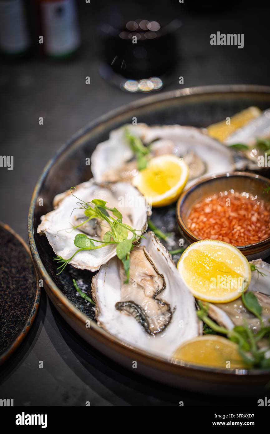 Astriche scozzesi fresche sul ghiaccio con aceto di scalogno, limone, germogli di pisello e lampone, servite per una cena di lusso, Scozia, Regno Unito Foto Stock