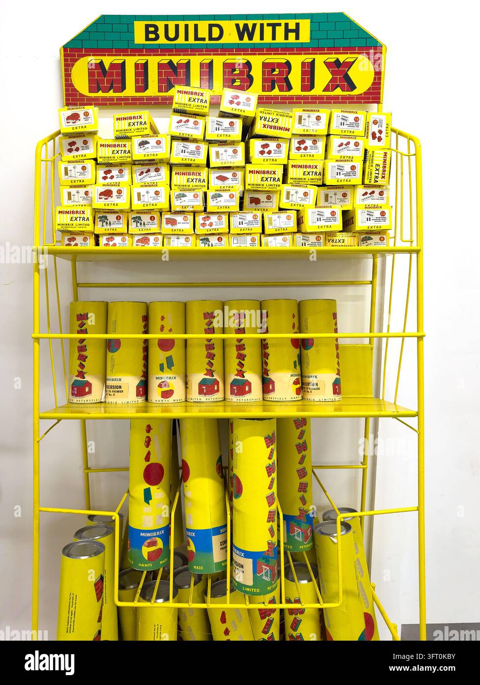 Scaffale espositivo giallo con scatole e cilindri di set di giocattoli vintage Minibrix Foto Stock
