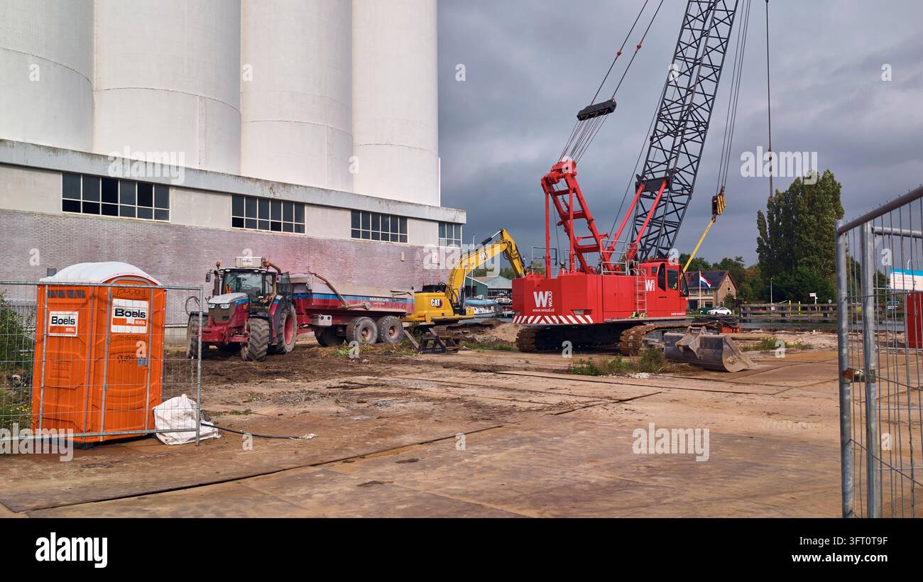 Wormerveer, Paesi Bassi, riqualificazione del cantiere con macchinari pesanti per la costruzione, tra cui un trattore con benna, un escavatore e una gru su cingoli per operazioni di getto di fogli al sito di Zaankwartier. Foto Stock