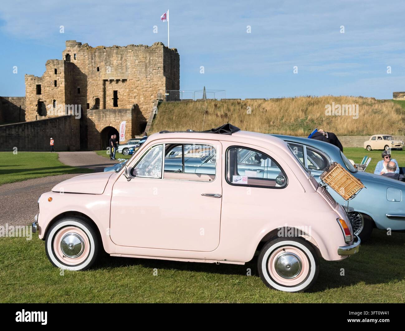 Fiat 500 vintage rosa classico parcheggiato al raduno automobilistico di Tynemouth Priory and Castle - Immagine stock catturata con smartphone