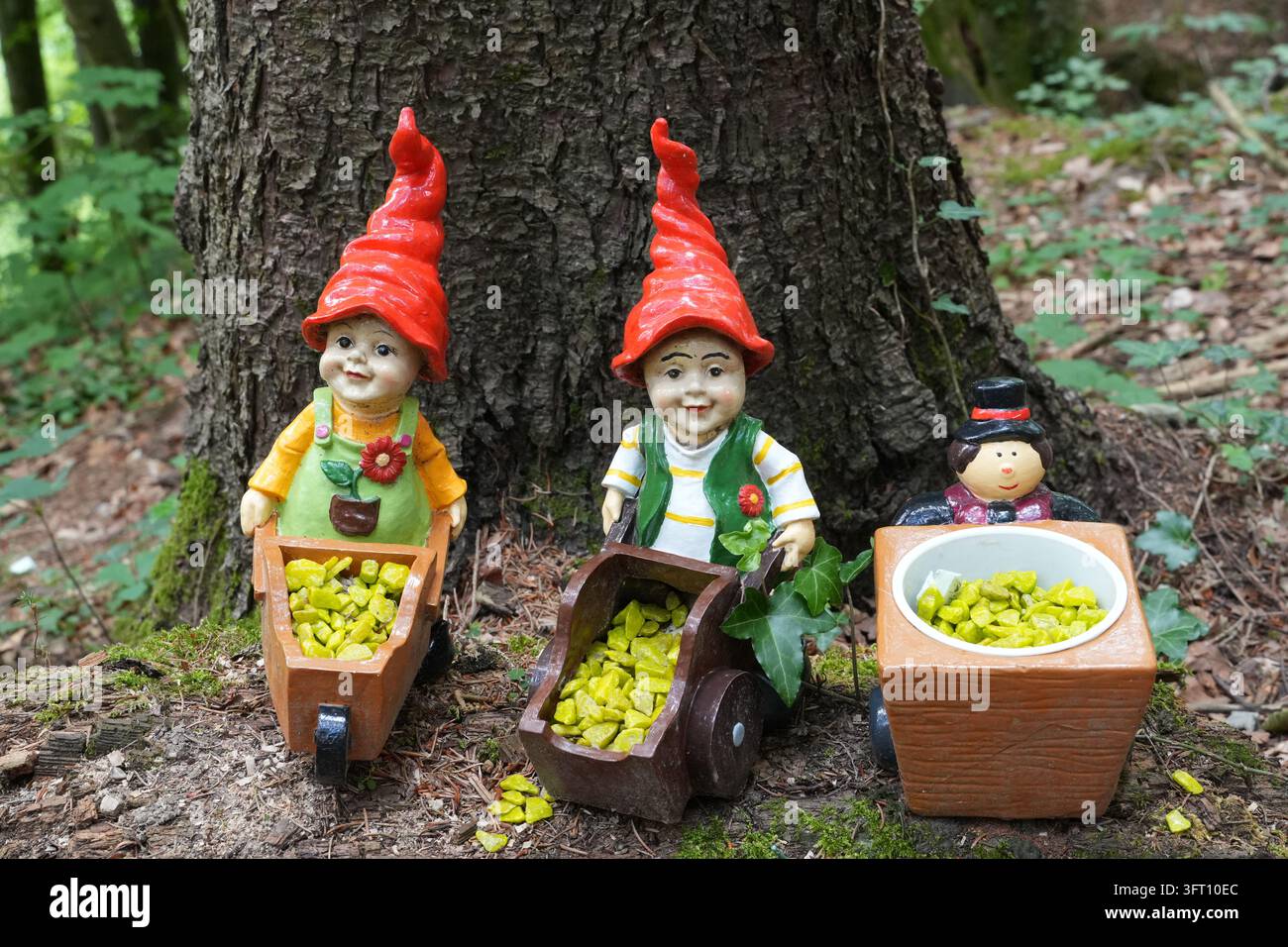 Nani da giardino colorati con cappelli rossi e carriole lungo il sentiero delle fiabe Zwergerlweg a Steinbach am Attersee, Alta Austria, Austria Foto Stock