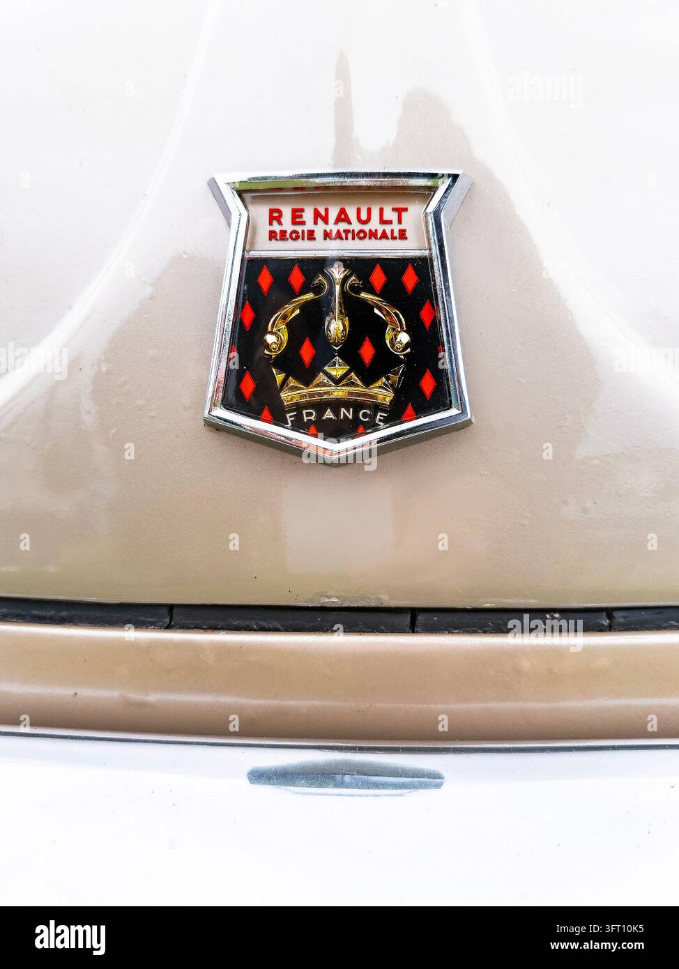 Emblema dell'auto Renault Dauphine in beige e oro con Regie Nazionale e stemma della Francia - Immagine stock catturata con smartphone