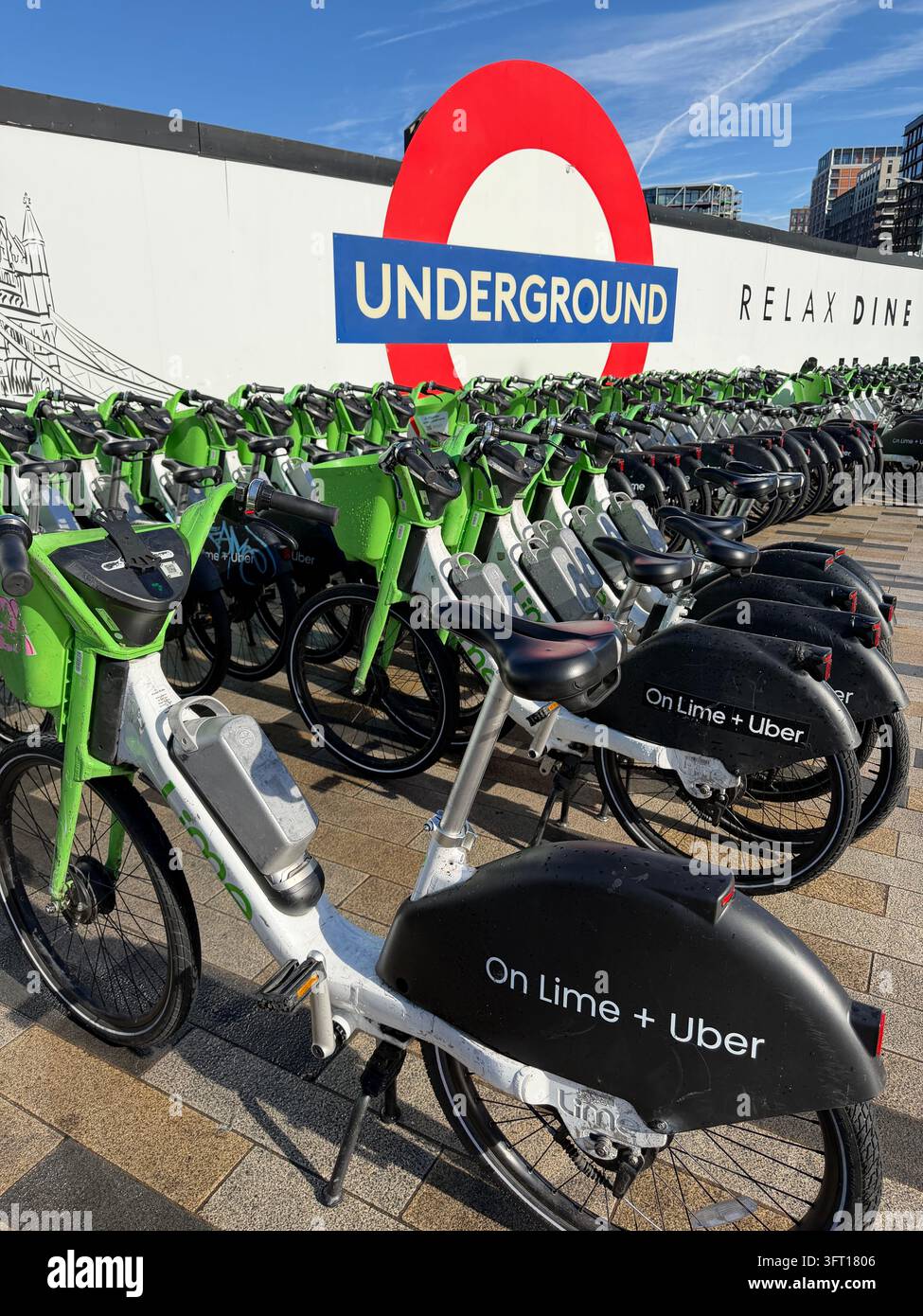 Biciclette Lime parcheggiate vicino alla Battersea Power Station nel centro di Londra. Le biciclette sono dotate di un sistema di assistenza al pedale che si attiva mentre si pedala. - Immagine stock catturata con smartphone