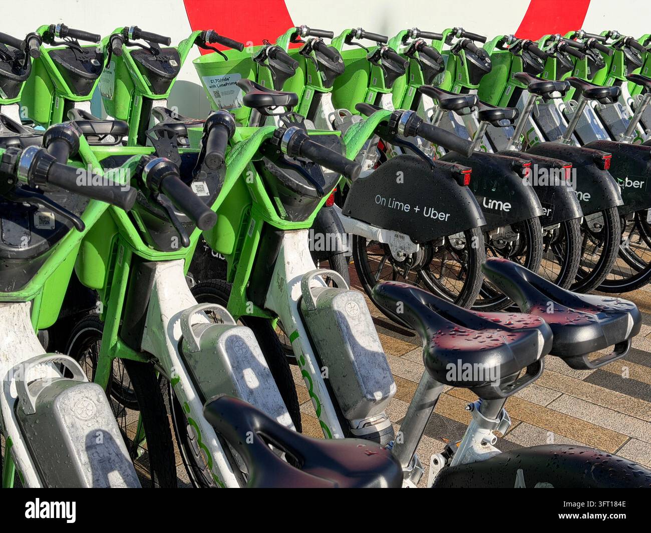 Biciclette Lime parcheggiate vicino alla Battersea Power Station nel centro di Londra. Le biciclette sono dotate di un sistema di assistenza al pedale che si attiva mentre si pedala. - Immagine stock catturata con smartphone