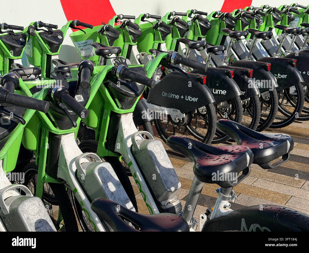 Biciclette Lime parcheggiate vicino alla Battersea Power Station nel centro di Londra. Le biciclette sono dotate di un sistema di assistenza al pedale che si attiva mentre si pedala. - Immagine stock catturata con smartphone