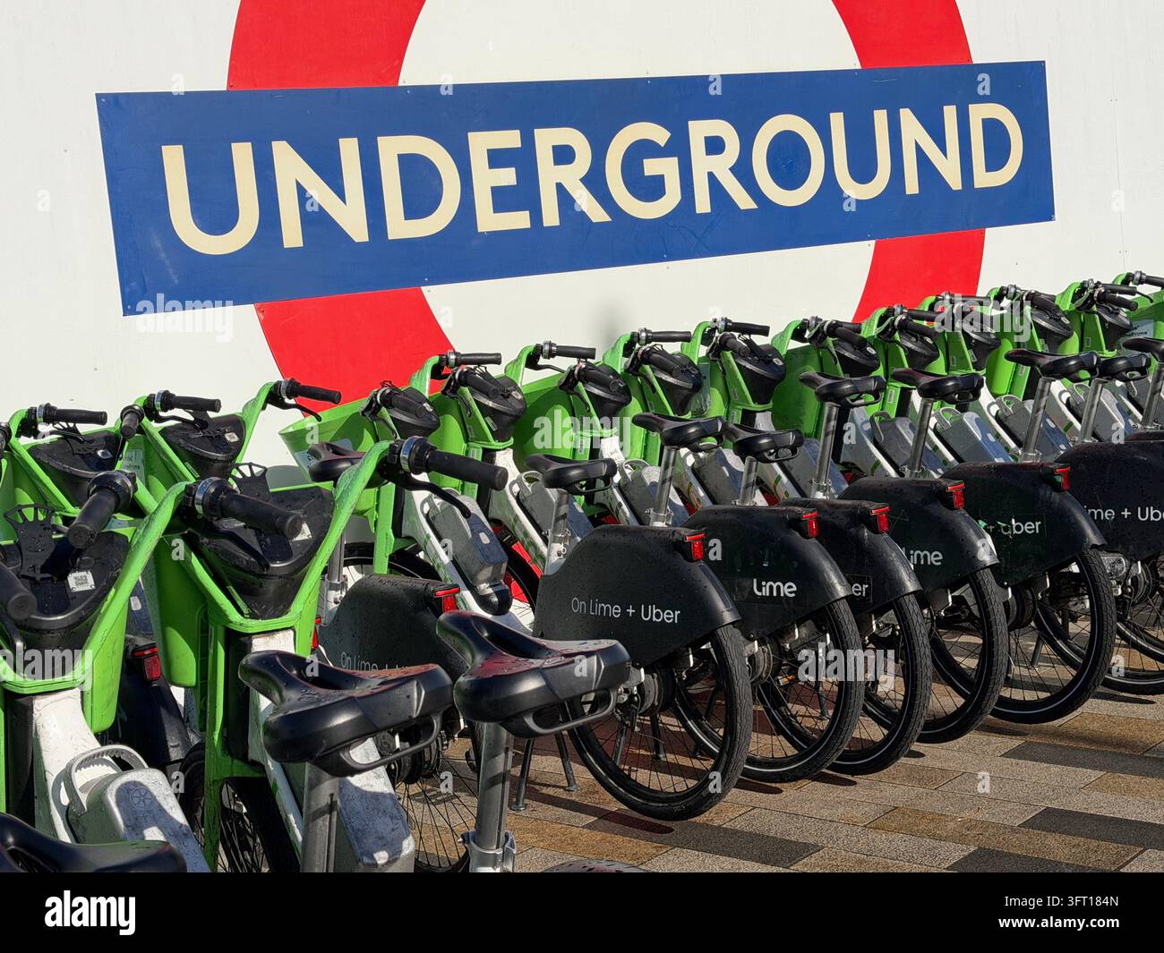 Biciclette Lime parcheggiate vicino alla Battersea Power Station nel centro di Londra. Le biciclette sono dotate di un sistema di assistenza al pedale che si attiva mentre si pedala. - Immagine stock catturata con smartphone