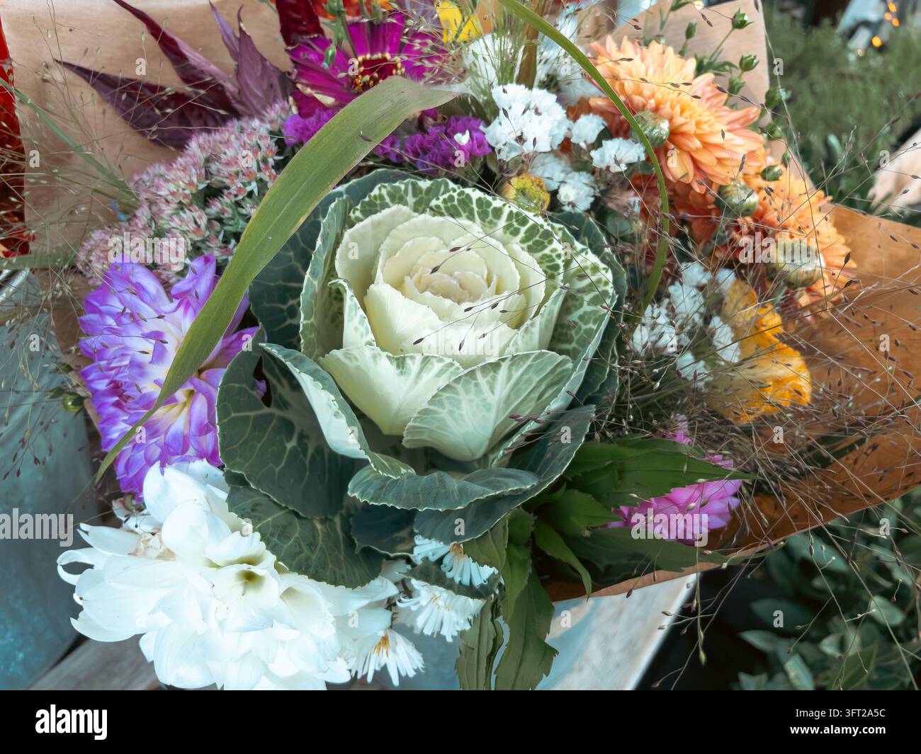 Mazzo di fiori autunnali con cavolo ornamentale avvolto in carta artigianale - Immagine stock catturata con smartphone