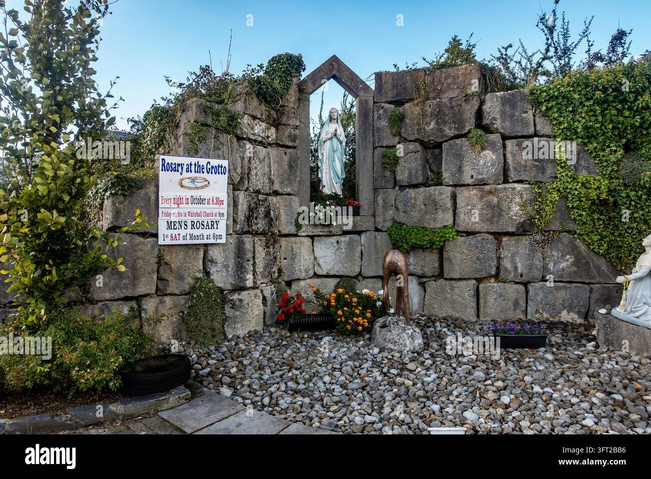 Un santuario mariano con una statua della Vergine Maria e un cartello che annuncia il Rosario degli uomini si trova in una grotta di pietra a Tarmonbarry, Contea di Roscommon, Irlanda. Foto Stock