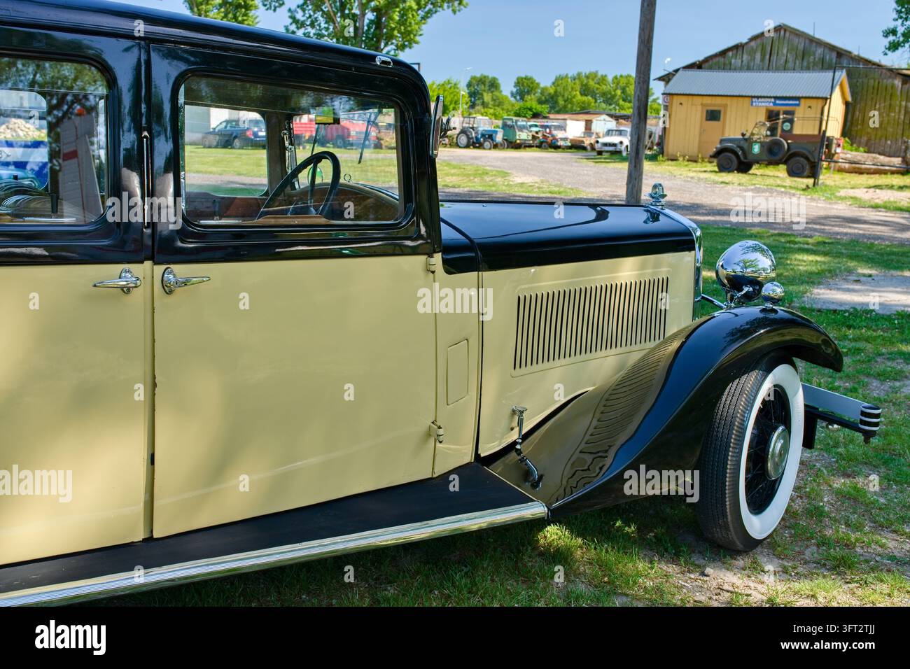 Descrizione inglese (Description): Una fotografia automobilistica che mostra un'auto storica vintage con un design bicolore giallo e nero della carrozzeria, parete bianca Foto Stock