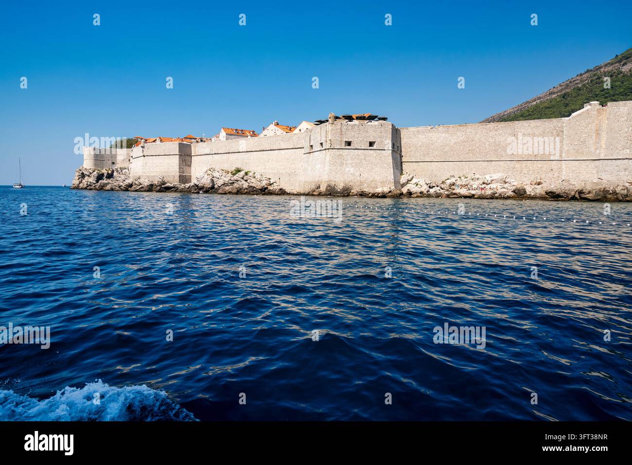 Panorama marittimo delle massicce mura medievali di Dubrovnik costruite direttamente sopra la costa rocciosa dell'Adriatico, adatte per viaggi in Croazia, difensivo a Foto Stock