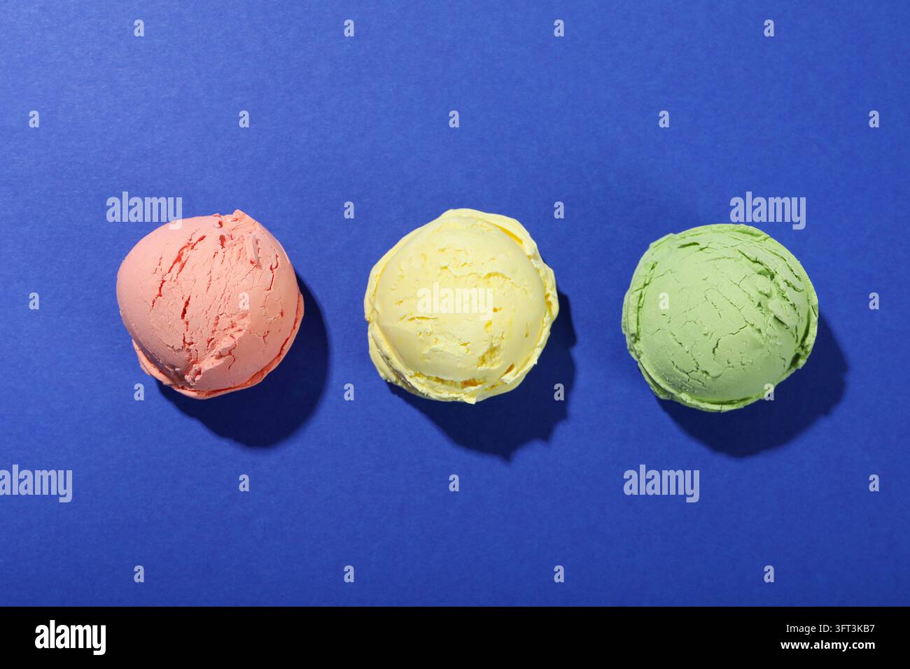 Tre palline di gelato su sfondo blu Foto Stock