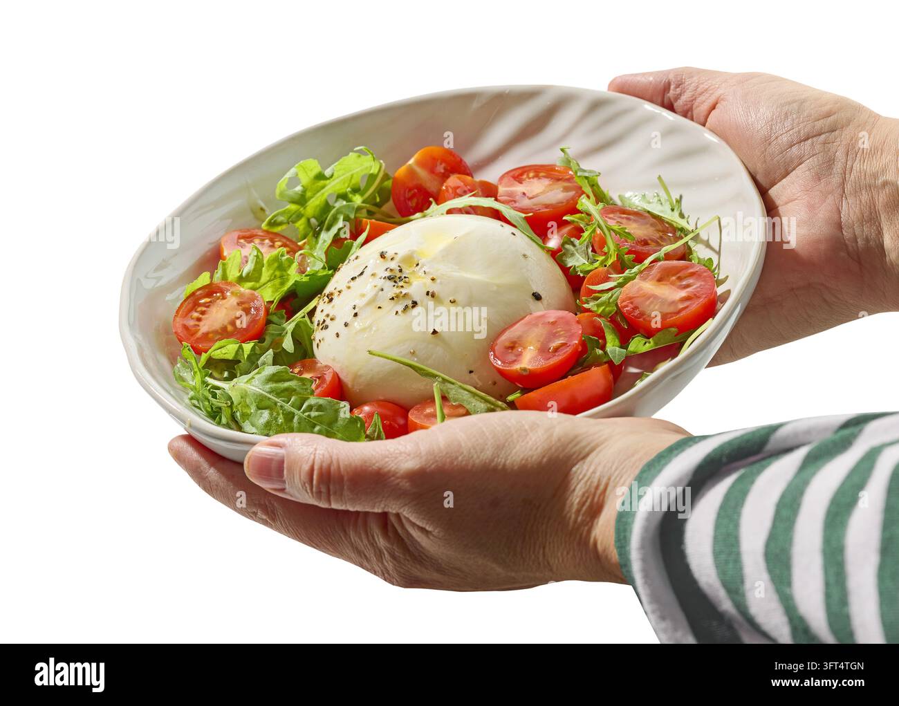 Ciotola di burrata appena preparata, pomodoro e insalata di rucola nelle mani di uno chef italiano, isolata su sfondo bianco Foto Stock