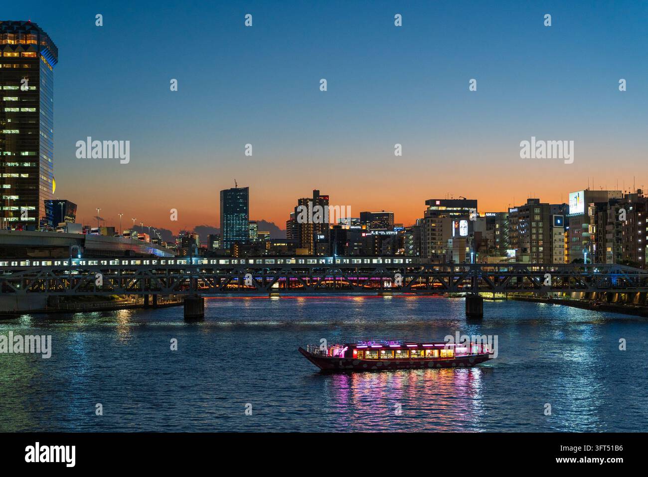 Skyline del fiume Sumida al crepuscolo con barca da piacere Yakatabune illuminata e ponte ferroviario. Tokyo, Giappone. Foto Stock
