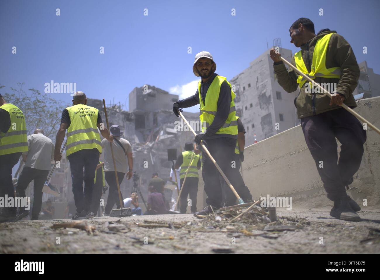 Spazzine stradali a Tel Aviv, Israele, che ripuliscono i detriti di un edificio residenziale dopo un attacco missilistico iraniano durante il conflitto Israele-Gaza. Foto Stock