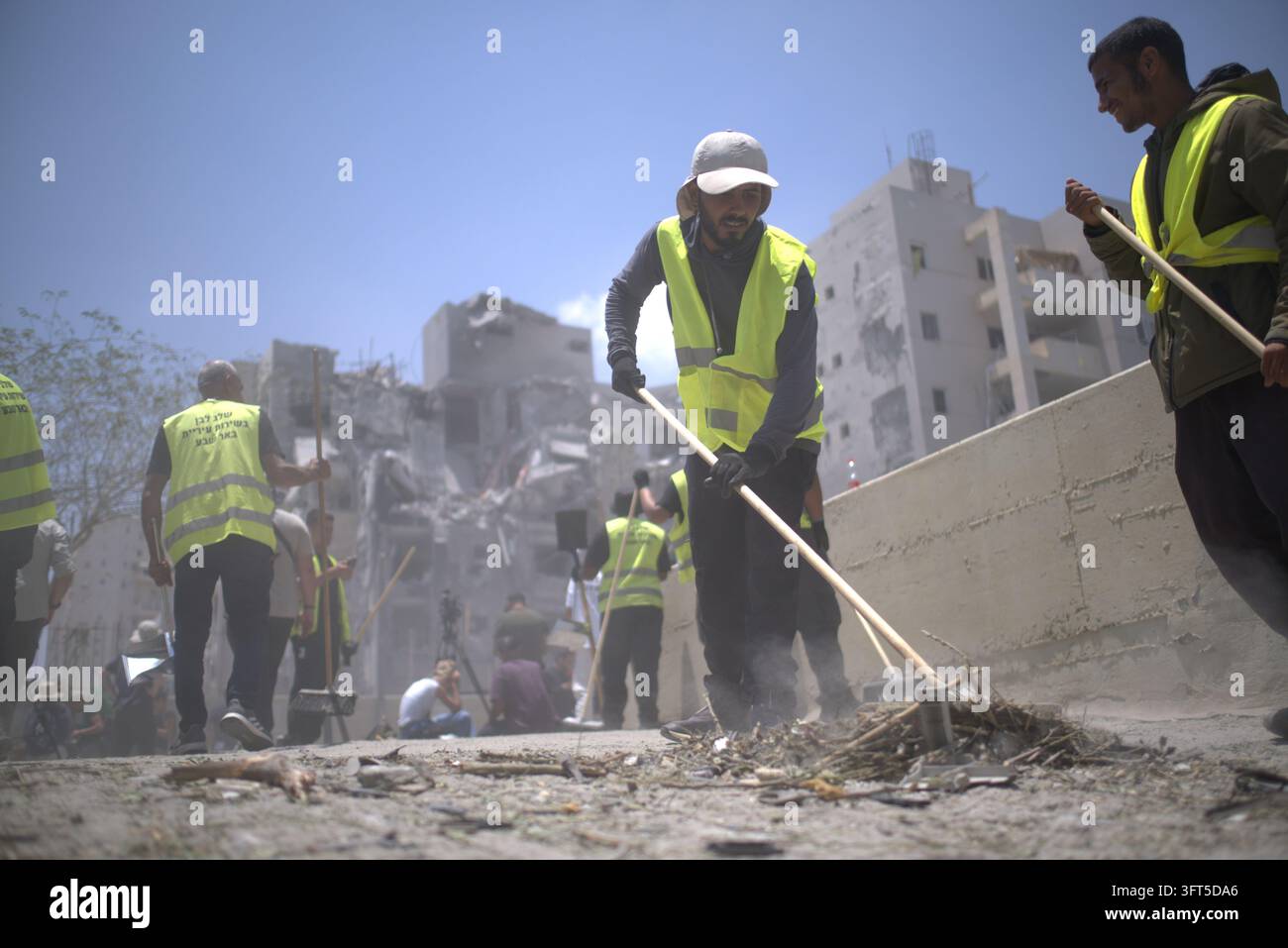 Spazzine stradali a Tel Aviv, Israele, che ripuliscono i detriti di un edificio residenziale dopo un attacco missilistico iraniano durante il conflitto Israele-Gaza. Foto Stock