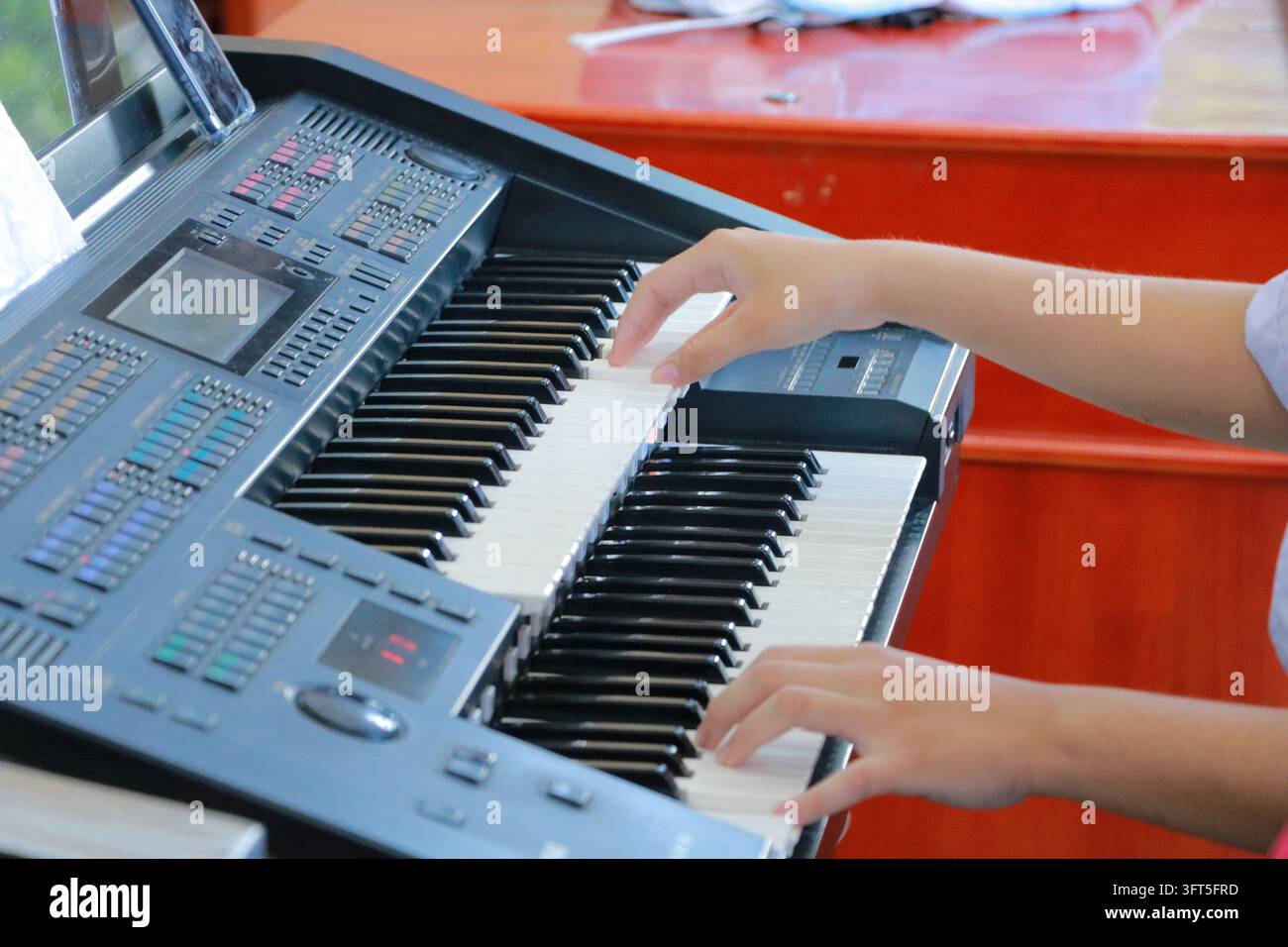 Primo piano di mani che suonano un organo elettronico a due manuali Foto Stock