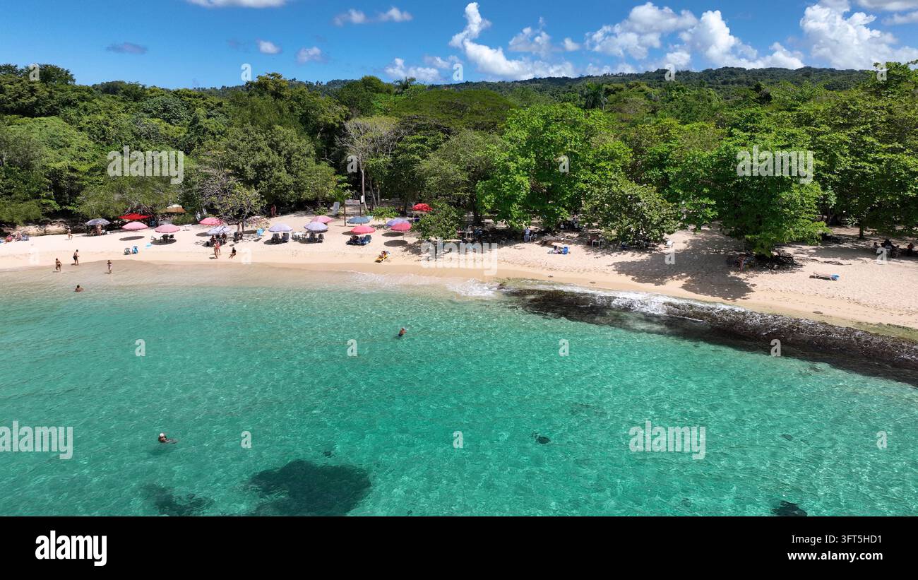 Vista aerea della spiaggia La Casita de Playa con acqua turchese, ombrelloni colorati sulla sabbia e alberi verdi rigogliosi a Rio San Juan, María Trinidad San Foto Stock