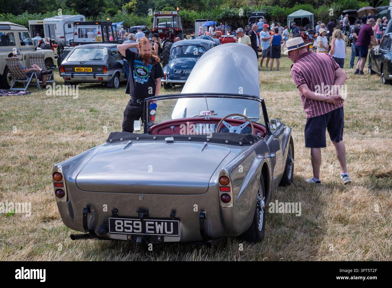 Uomini che ammirano un'auto sportiva classica Daimler Dart degli anni '60 a un rally vintage, Tissington, Derbyshire Foto Stock