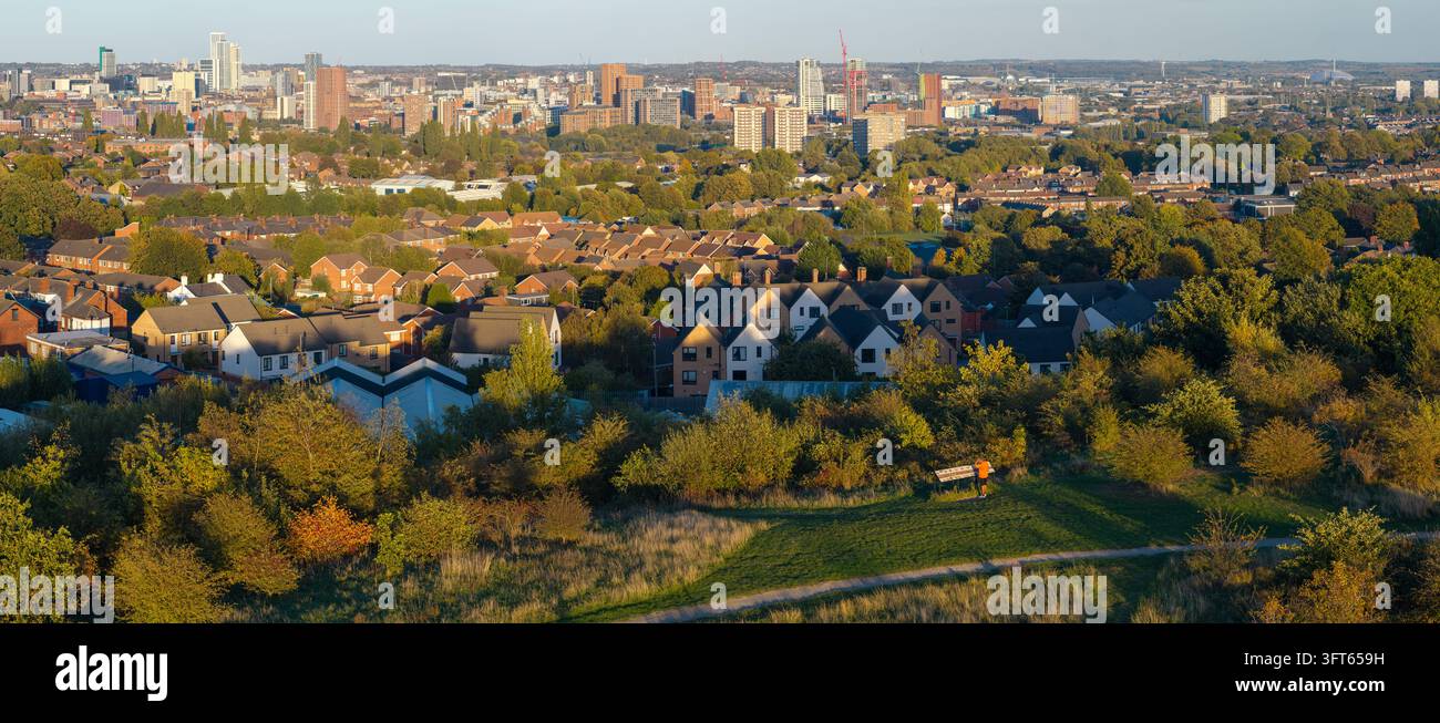 Vista aerea panoramica sul prato di Cabbage Hill con un visitatore che guarda oltre i tetti residenziali di Wortley verso lo skyline del centro città di Leeds Foto Stock