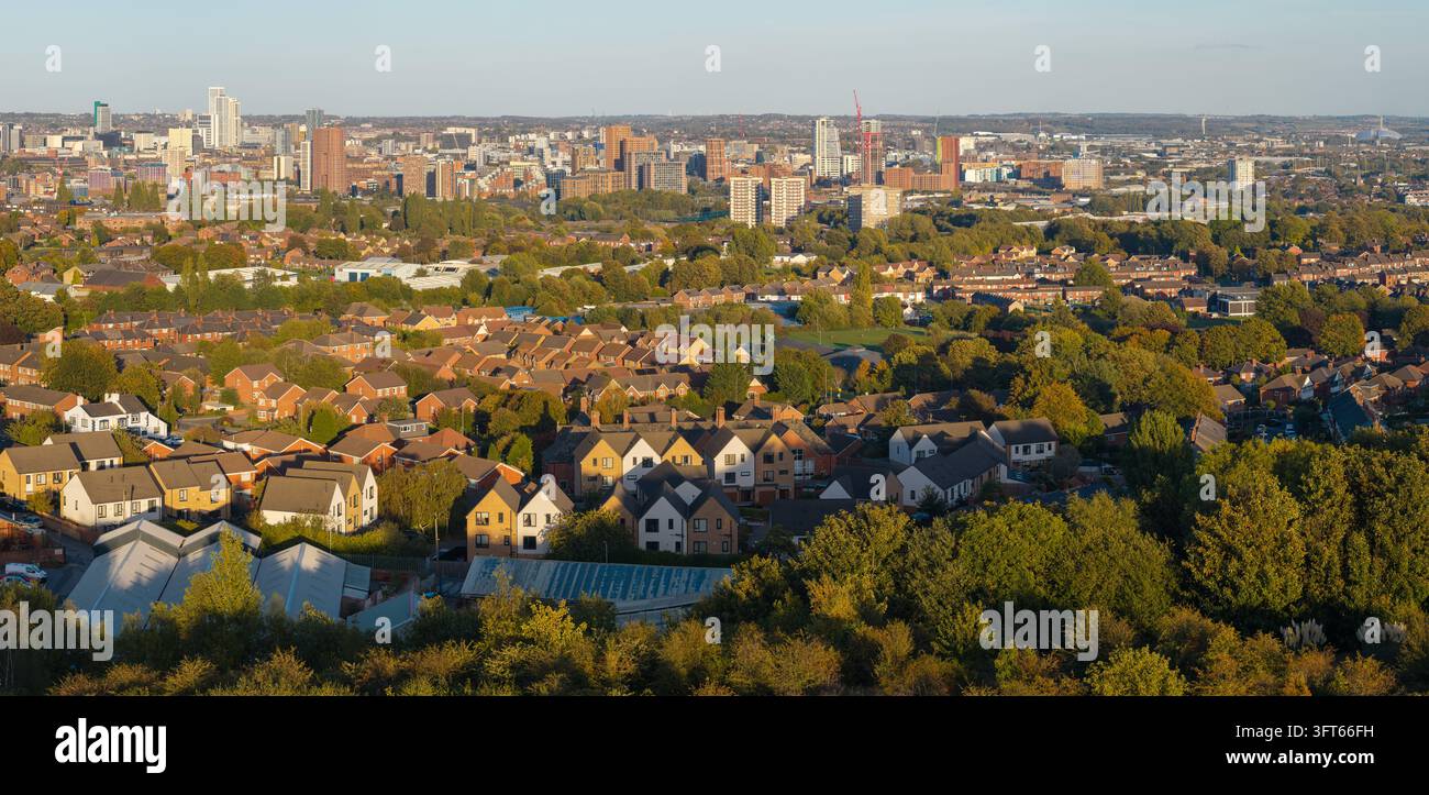 Vista aerea panoramica che cattura i quartieri residenziali di Wortley che conducono verso lo skyline del centro città di Leeds con moderni grattacieli Foto Stock