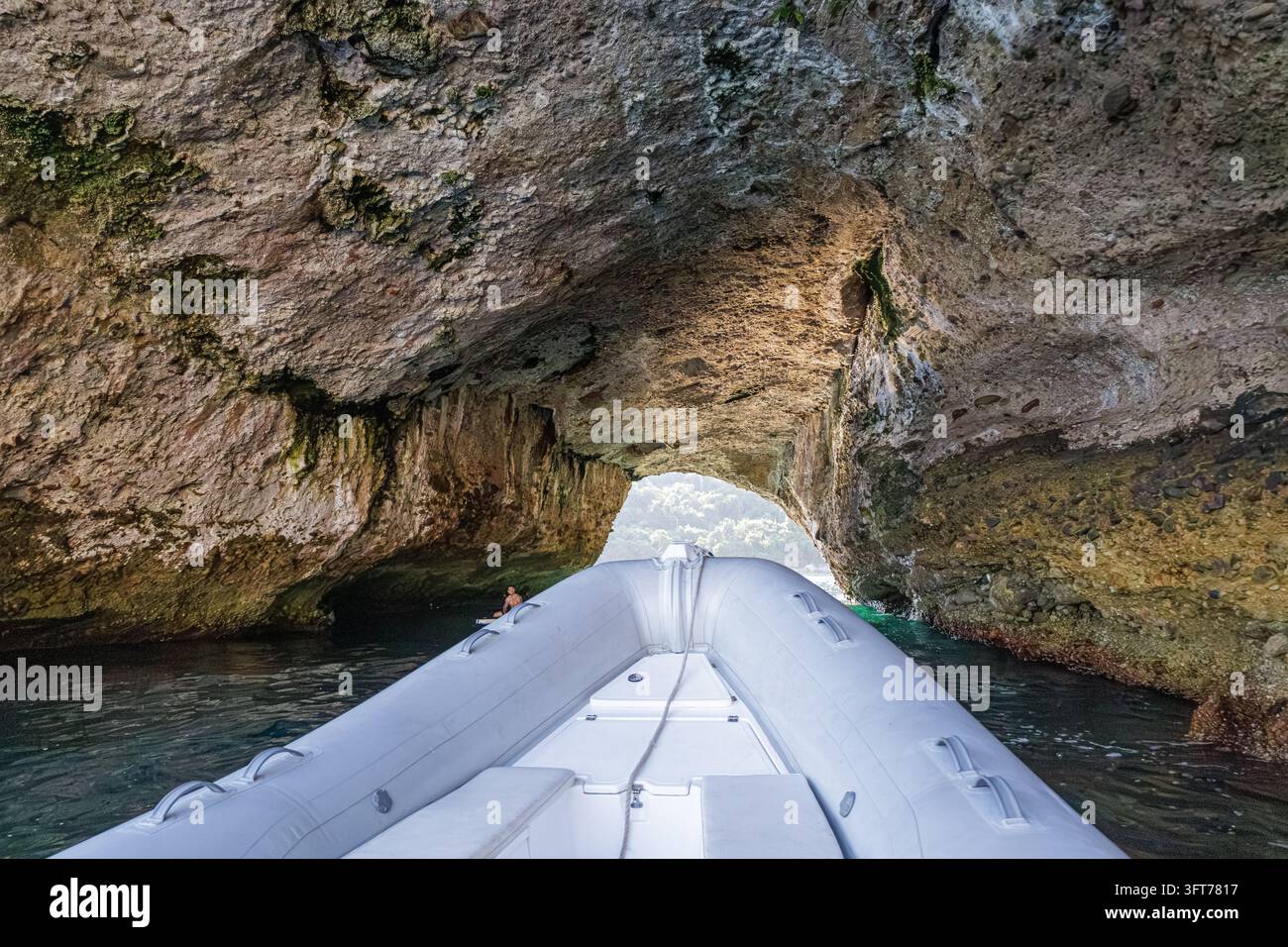 Motoscafo che passa sotto un arco naturale a Los Arcos de Mismaloya. Foto Stock