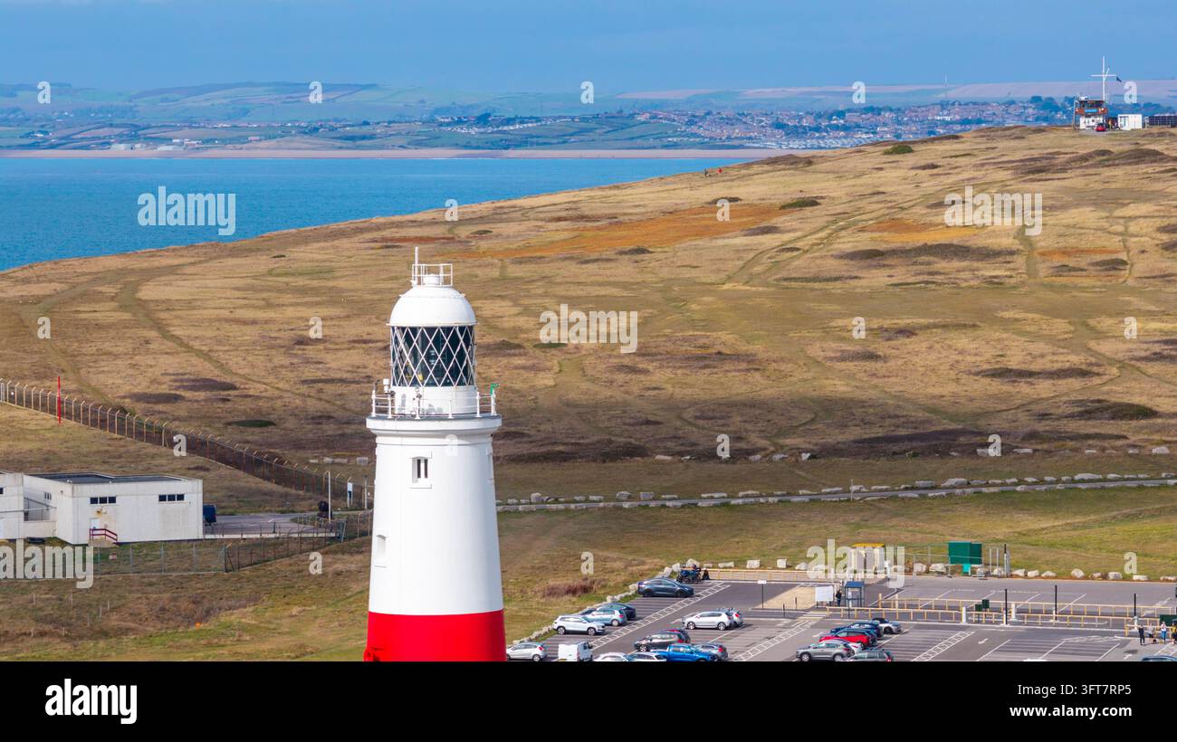 Vista aerea del faro di Portland Bill con la sua torre rossa e bianca, contro il paesaggio costiero frastagliato dell'Isola di Portland, Portland, Engl Foto Stock