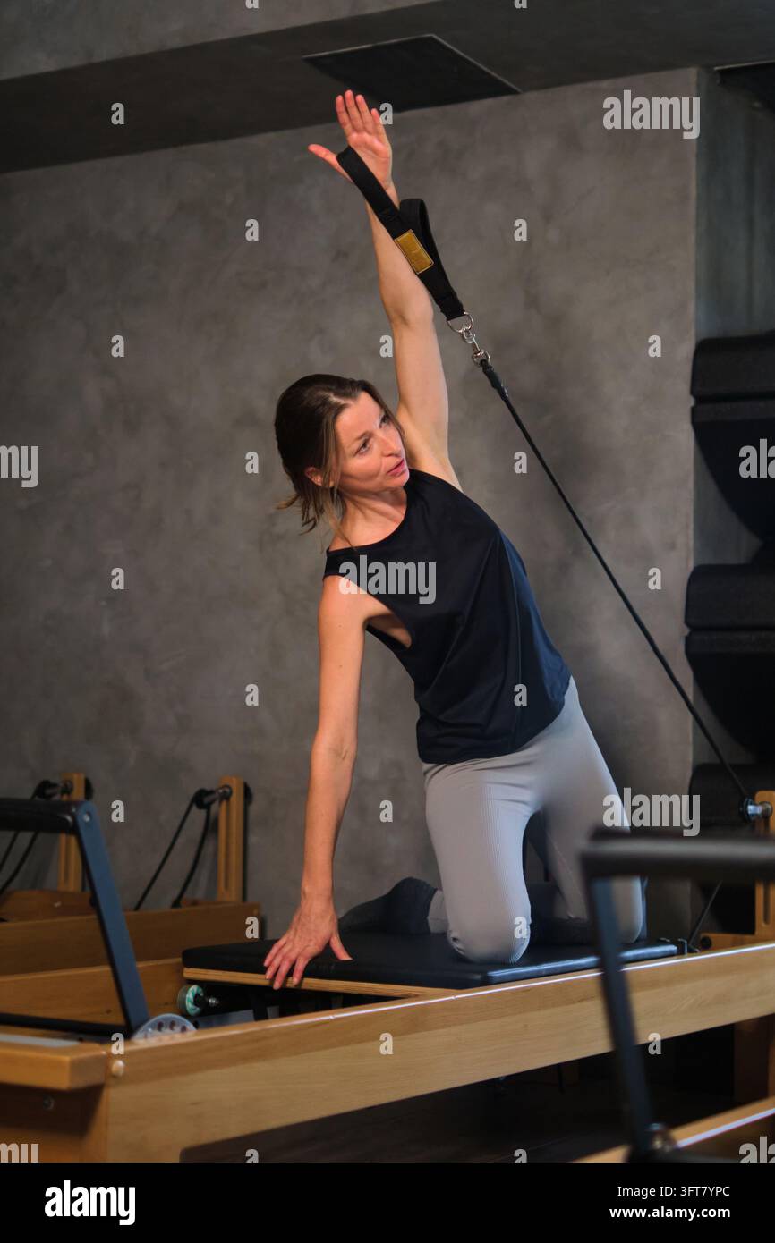 Istruttrice di Pilates che si allunga con una fascia di resistenza Foto Stock