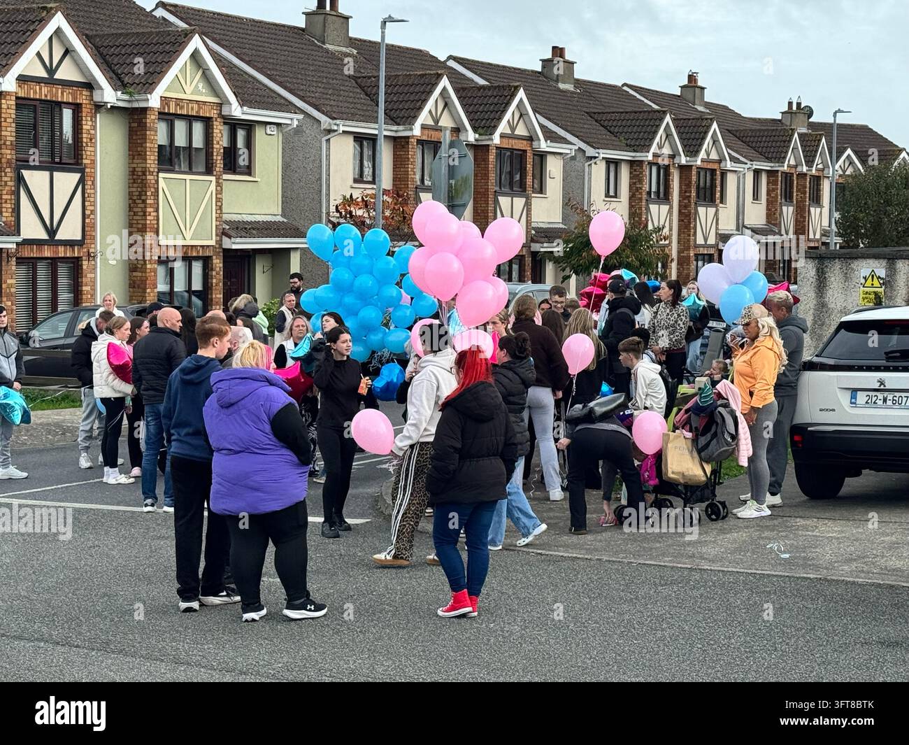 Le persone si radunano in vista di una cerimonia di rilascio di palloncini, per commemorare le vite perse in un incendio doloso a Birchwood, Waterford. Diverse proprietà sono state perquisite nell'ambito di un'indagine continua dei Garda sull'incendio che ha causato la morte di due adulti e due bambini, ma non sono stati effettuati arresti. Data della foto: mercoledì 14 ottobre 2026. Foto Stock