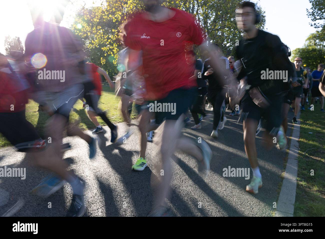 L'inizio di Parkrun al Gladstone Park Londra NW2 Willesden. I corridori sono sfocati per trasmettere velocità. Foto Stock