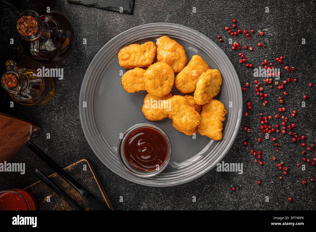 Nuggets di pollo con salsa su piatto grigio Foto Stock