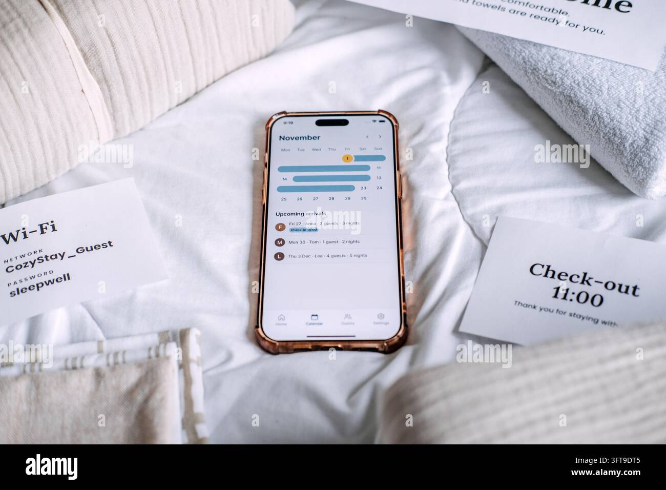 Vista ravvicinata di note stampate di partenza e di rete accanto all'app del calendario degli affitti sul letto, regole di hosting quotidiane per soggiorni brevi Foto Stock