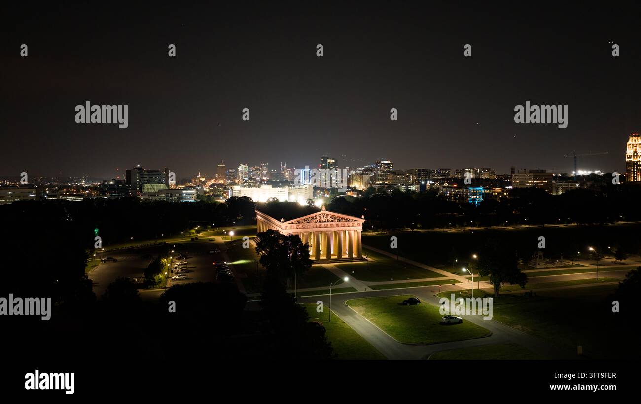 Nashville, Tennessee, Stati Uniti - 24 maggio 2023: Veduta aerea del Partenone illuminato nel Centennial Park di notte con lo skyline della città di Nashville Foto Stock