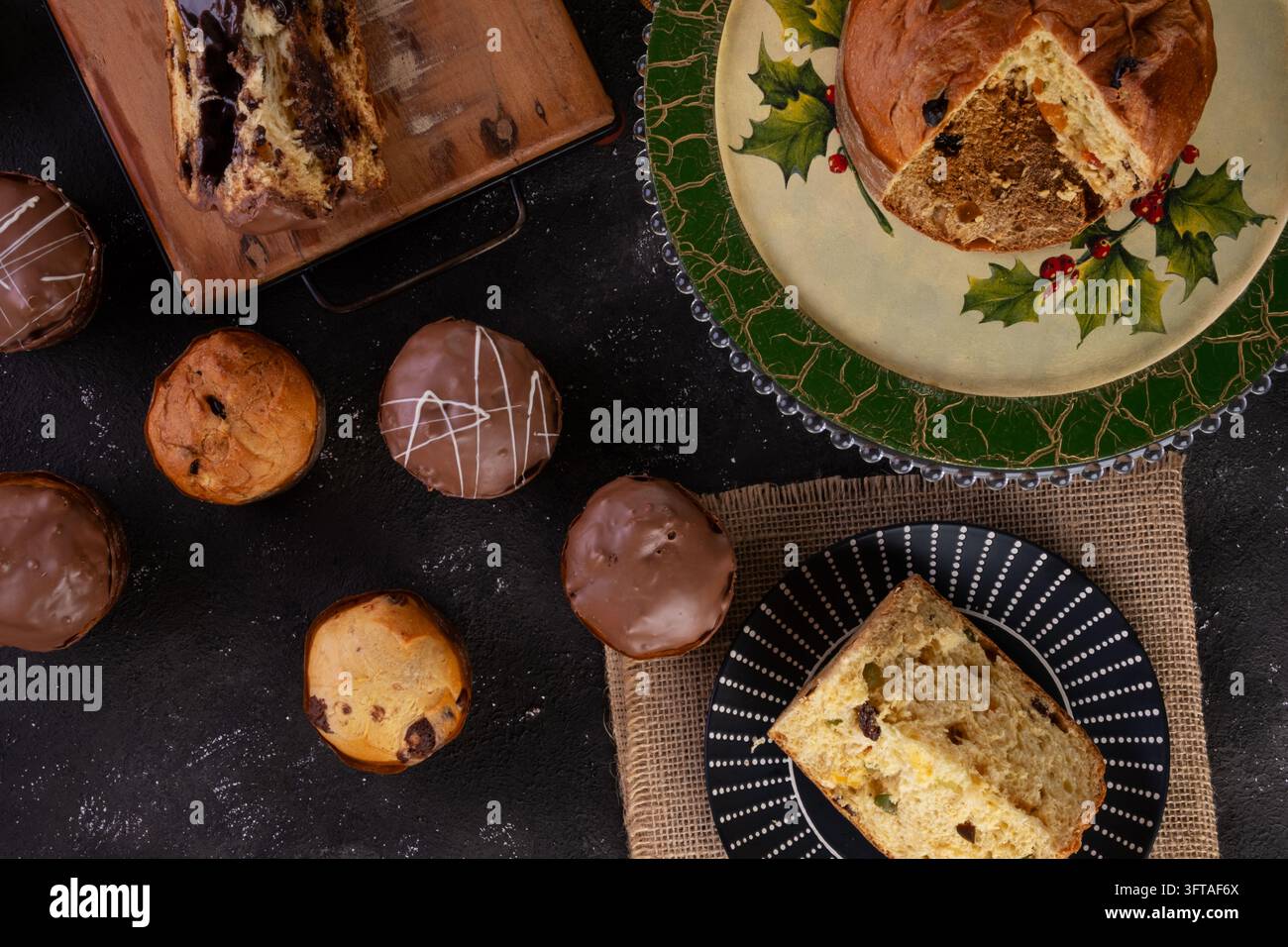 Vista aerea piatta di vari dolci italiani natalizi, tra cui il tradizionale panettone alla frutta e il ricco chocotone ripieno di cioccolato. La disposizione Foto Stock