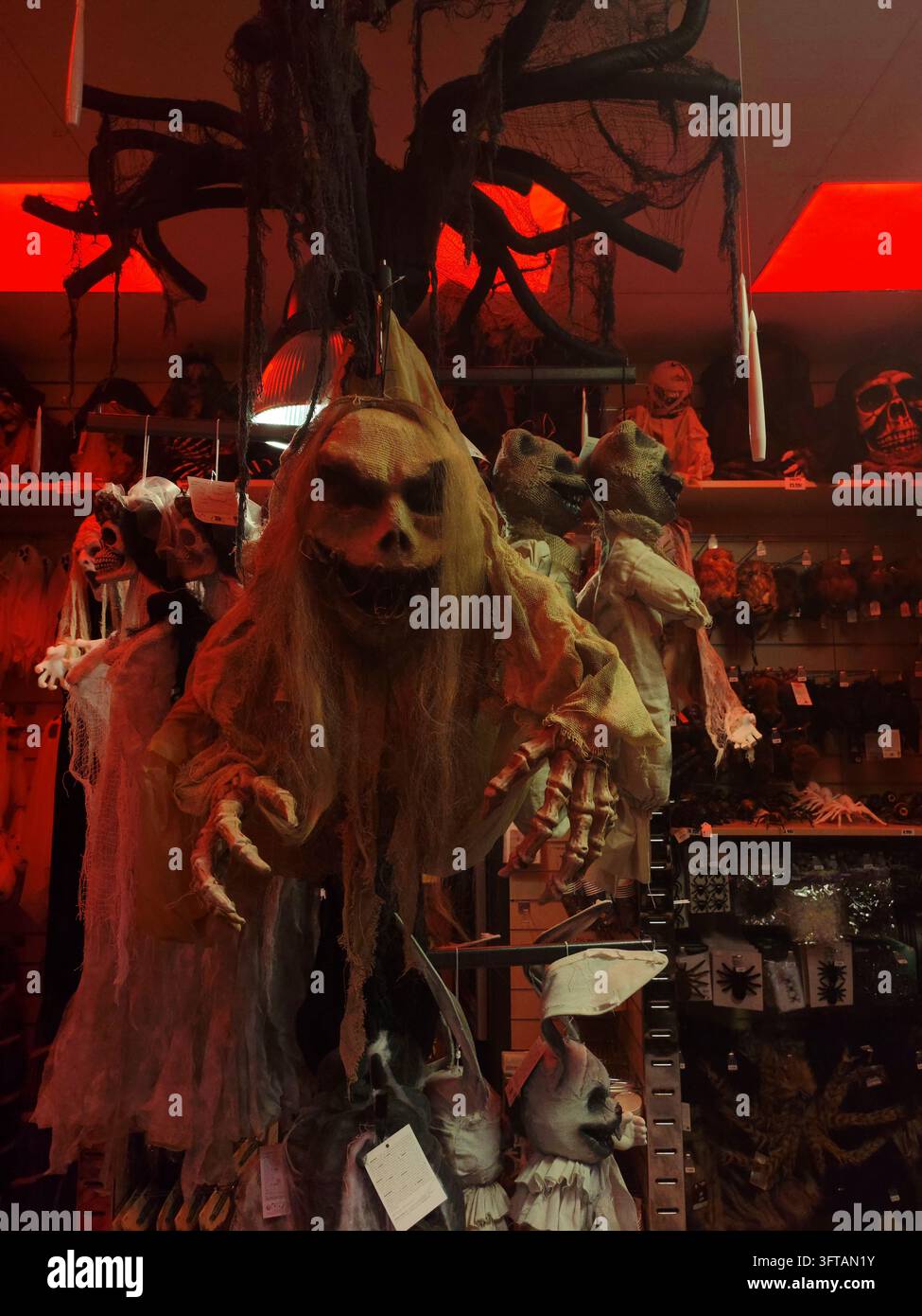 Manichini di clown inquietanti, teste di gomma insanguinate, maschere, ragni, scheletri e teschi, costumi esposti sugli scaffali di un negozio per Halloween. Foto Stock