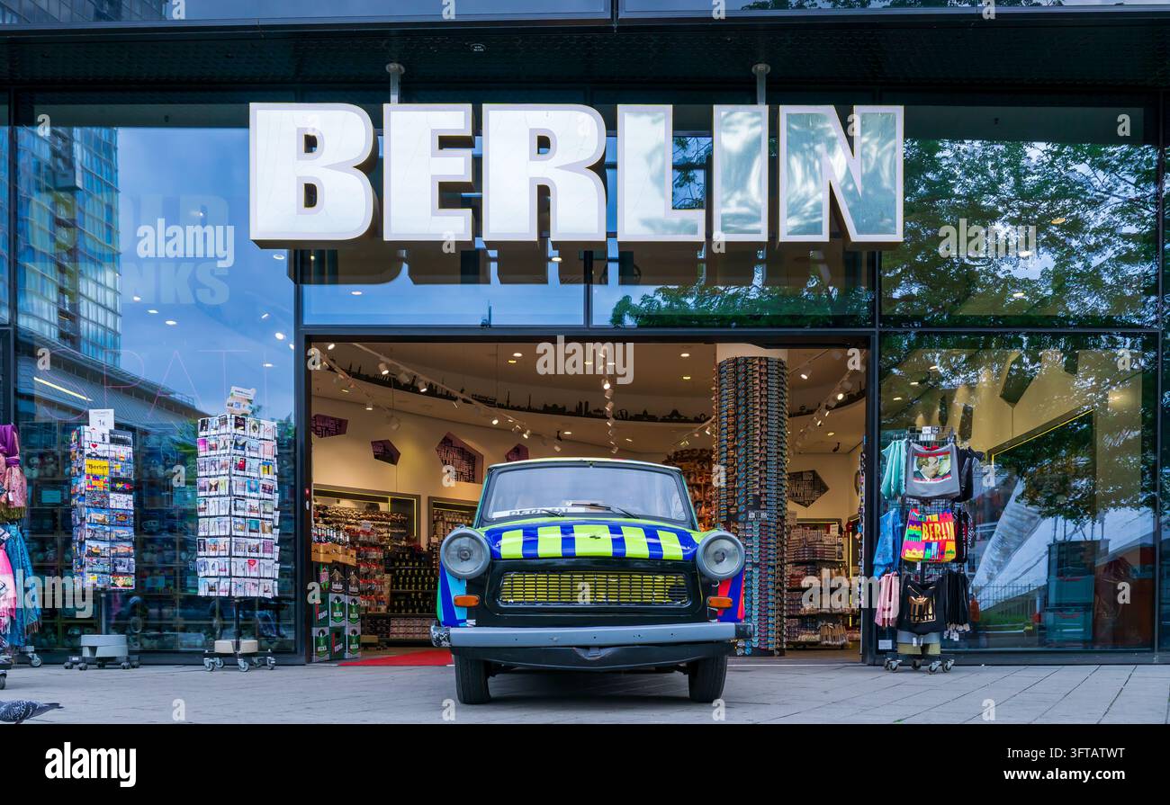Una Trabant colorata si trova all'ingresso di un negozio di souvenir sotto le grandi lettere BERLIN vicino all'Alexanderplatz a Berlino Mitte, Germania. Foto Stock